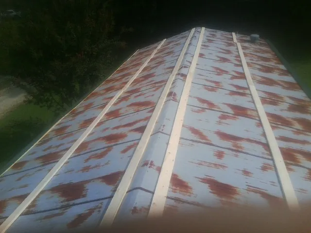 Rusted metal roof panels with new wood purlins before replacement — Storm Damage Roof Repair in Manteo by Roofing Brothers